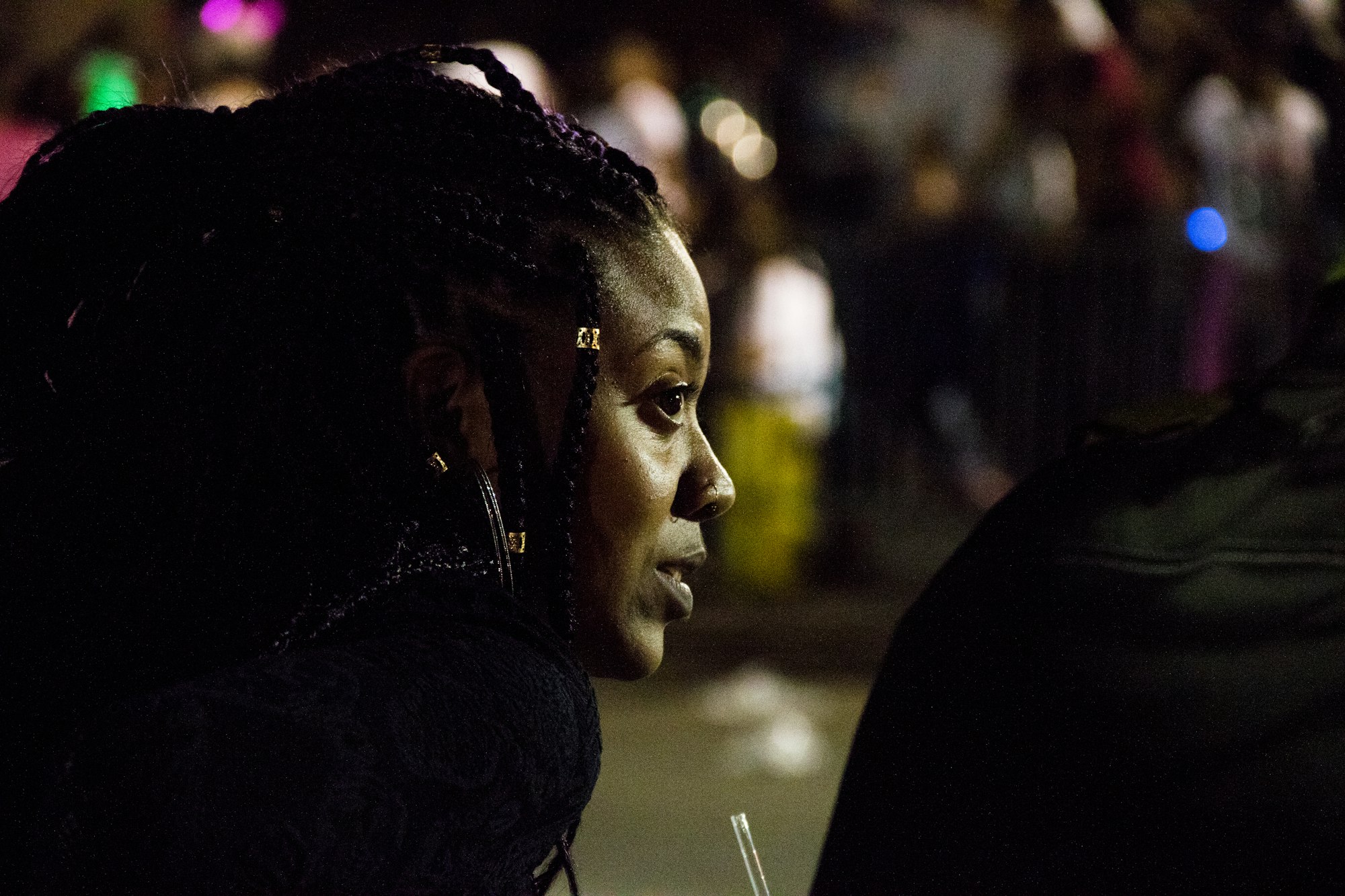 Spectator watching a night Mardi Gras parade in New Orleans