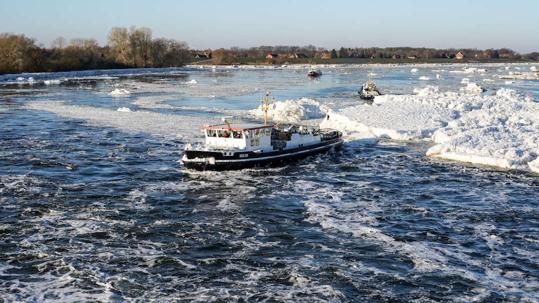 A boat navigates through icy river water.