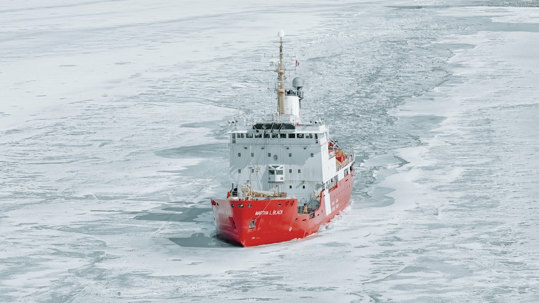 A red and white icebreaker ship cutting through icy water