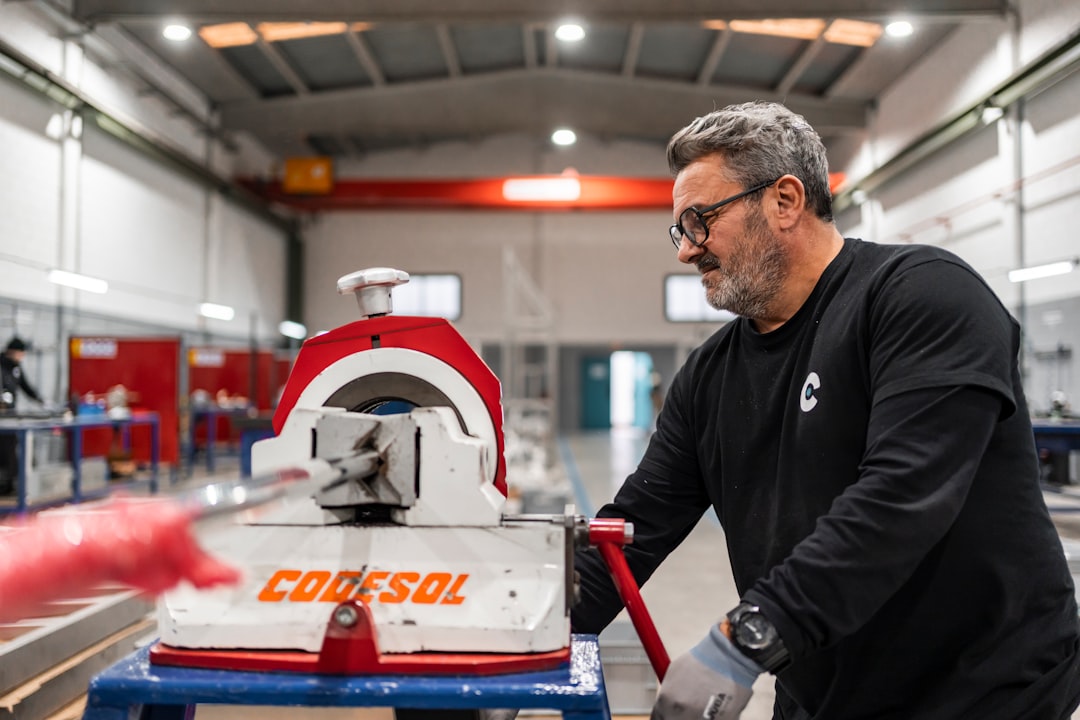 A man operates industrial machinery in a workshop.