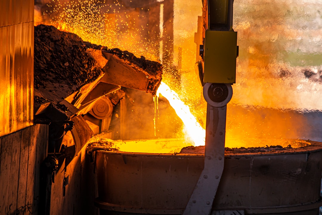 Molten metal pouring from a furnace into a large industrial ladle