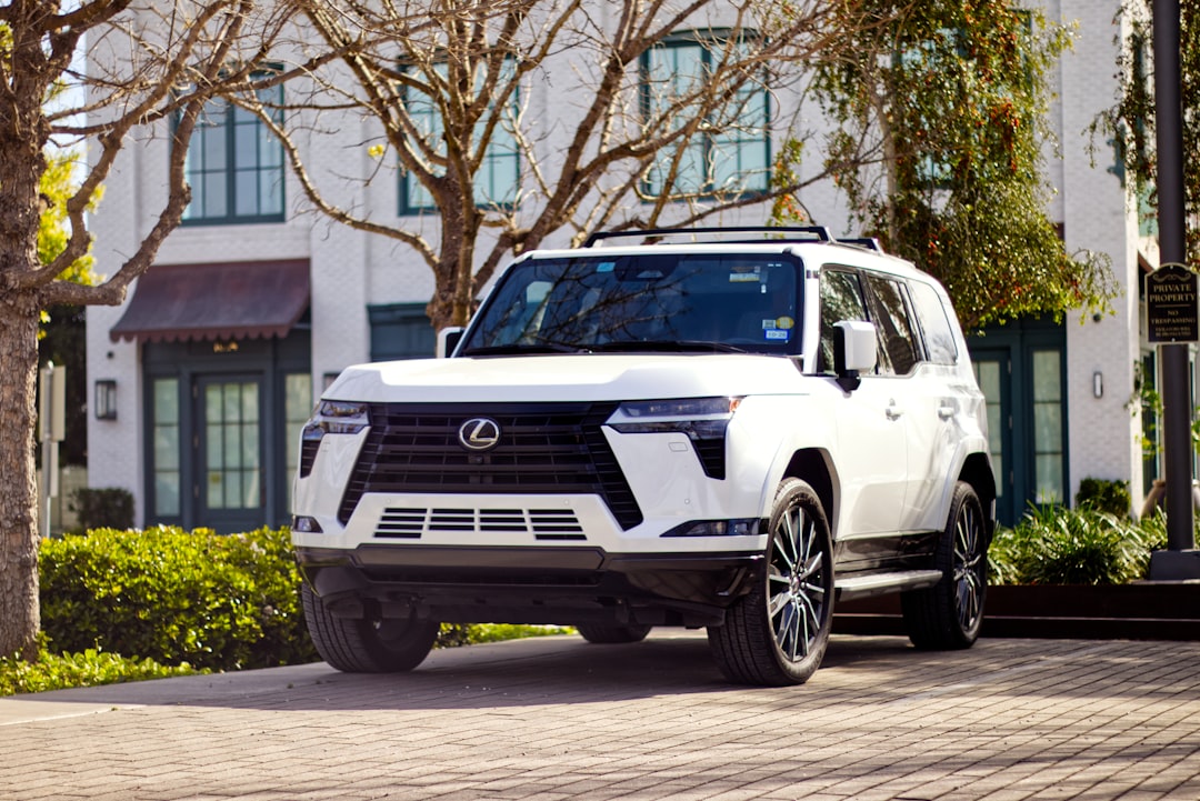 A white lexus suv parked in front of a building.