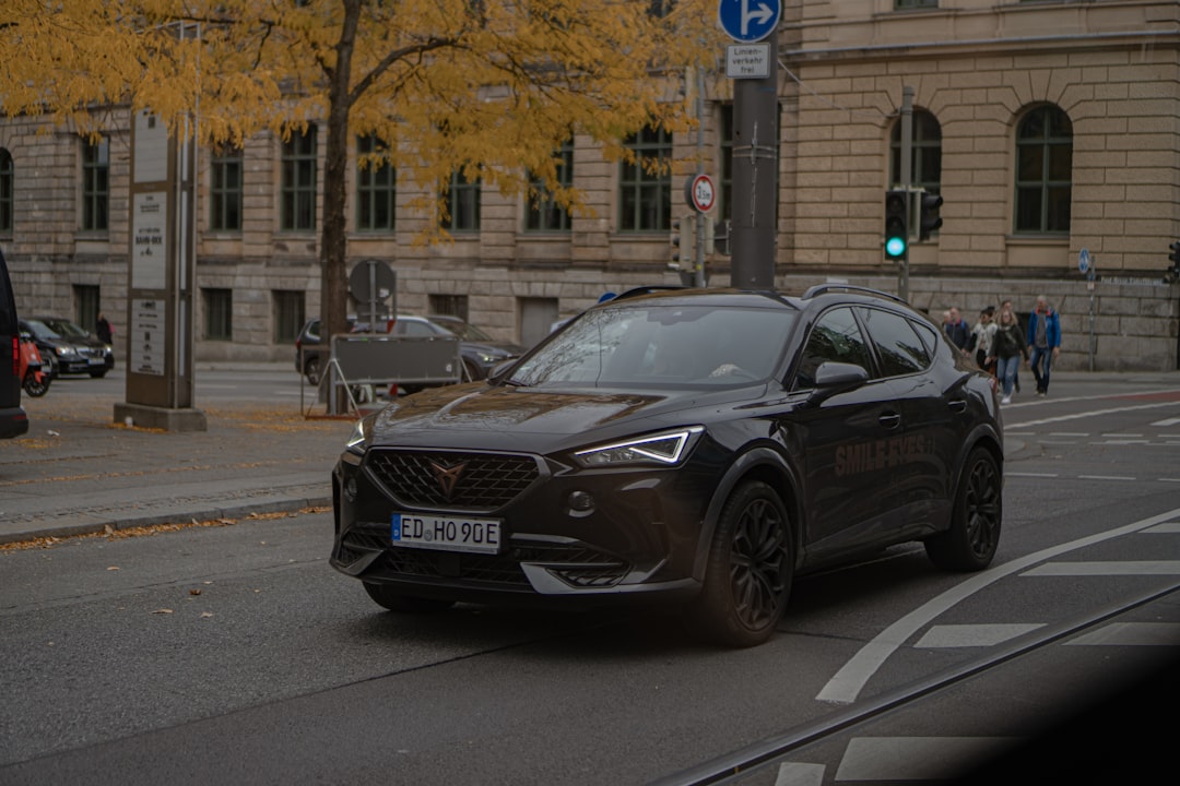a car driving down a street next to a tall building