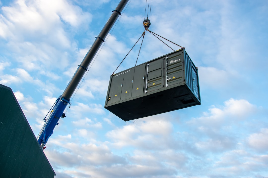 Crane lifting a large shipping container against the sky