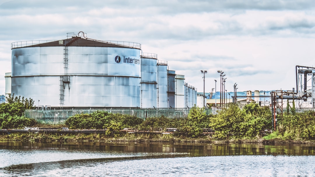 a large industrial building next to a body of water