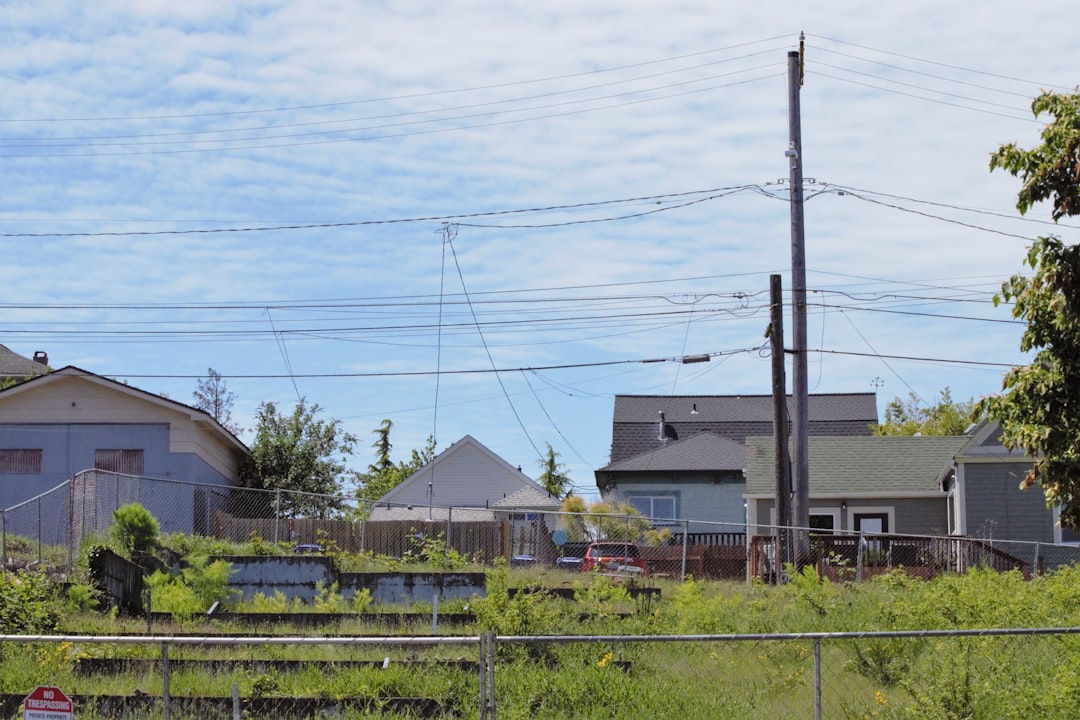 a fenced in area with houses in the background