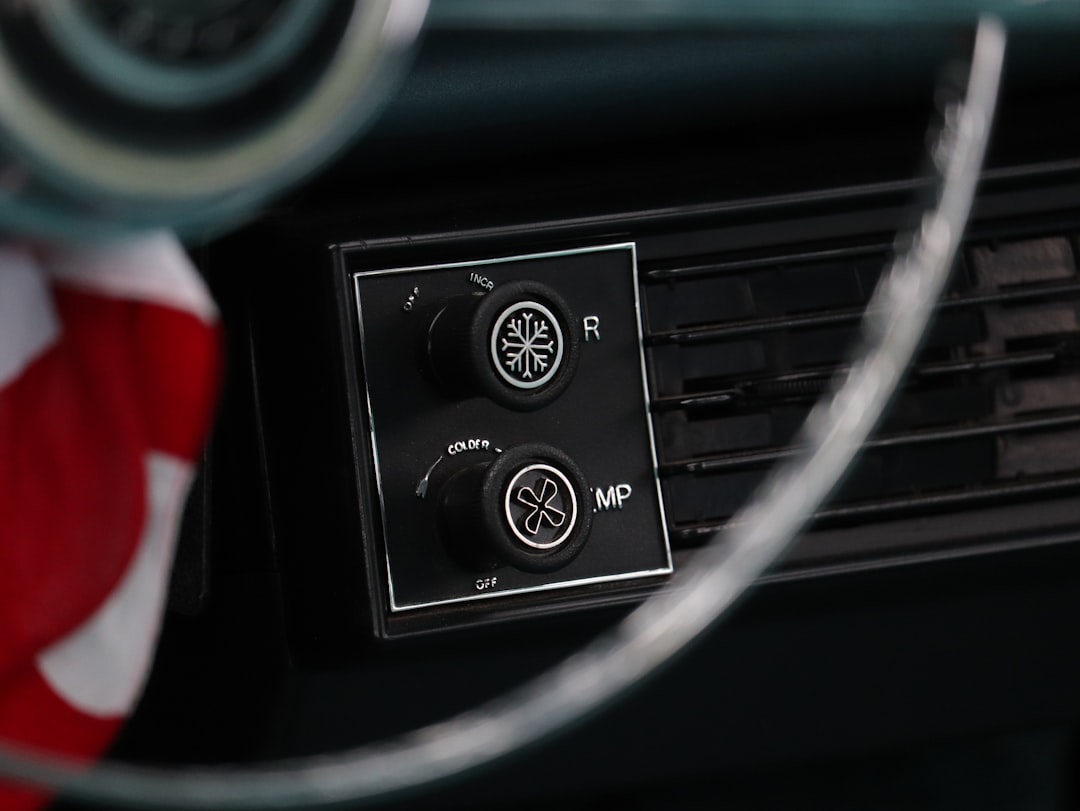 Vintage car dashboard with air conditioning controls.