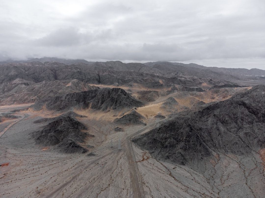 brown and green mountains under white clouds during daytime